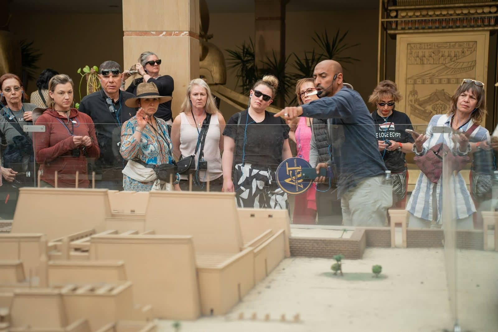 A guide explaining a temple model to a group of travelers