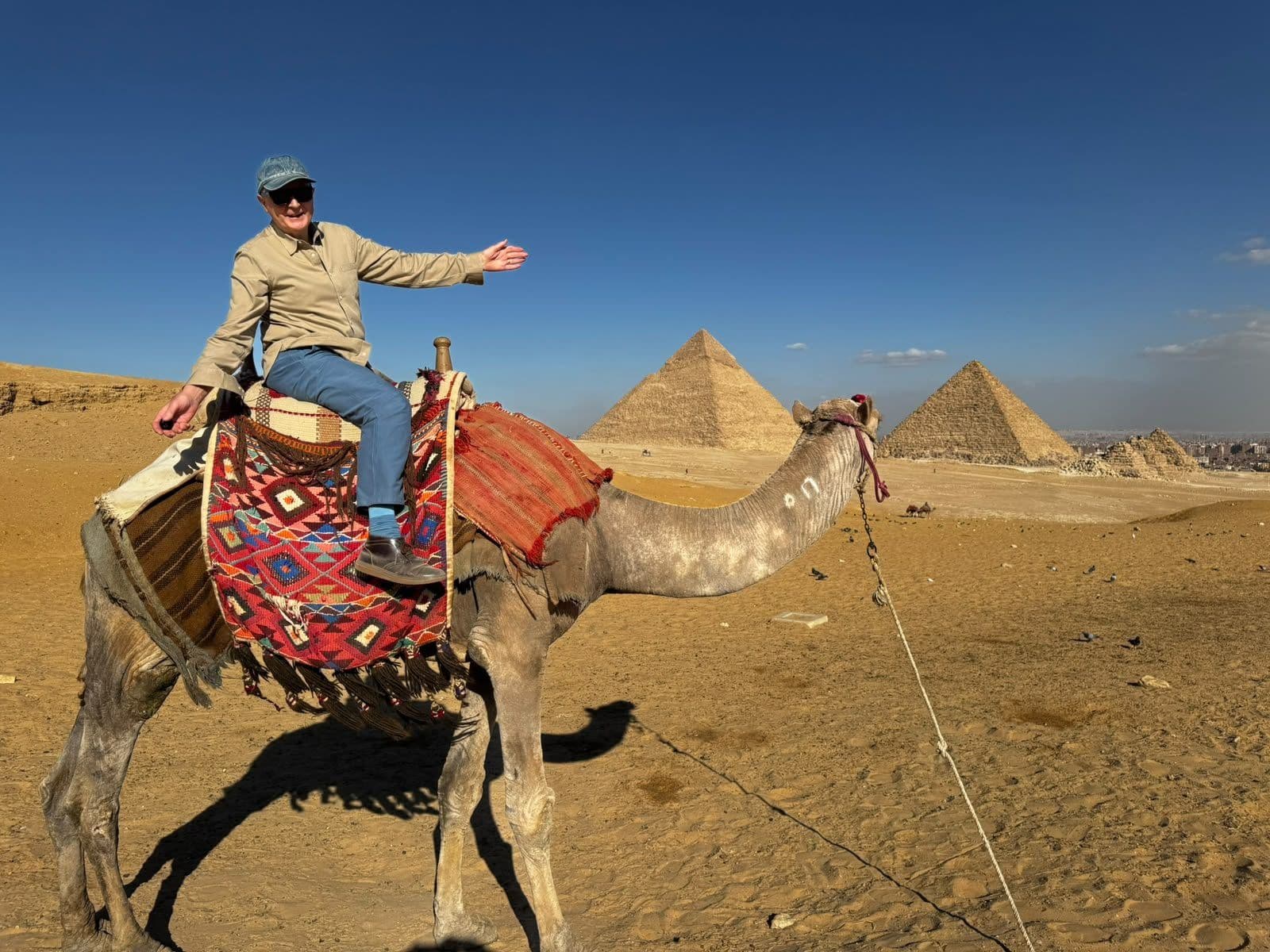 Reisende auf Kamelen vor den Pyramiden von Gizeh